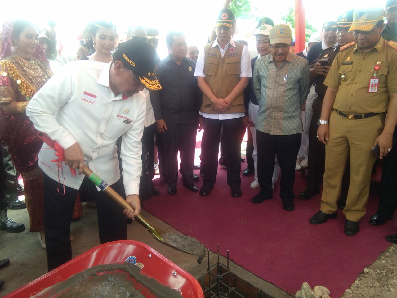 Menko Polhukam RI Wiranto menyekop campuran semen pada peletakan batu pertama hunian tetap Yayasan Buddha Tzu Chi di Desa Pombewe Kabupaten Sigi, Senin, 1 Juli 2019. Wiranto didampingi Menteri ATR/BPN Sofjan Djalil, dan Kepala BNPB Letjen TNI Doni Monardo. (Foto Patar)